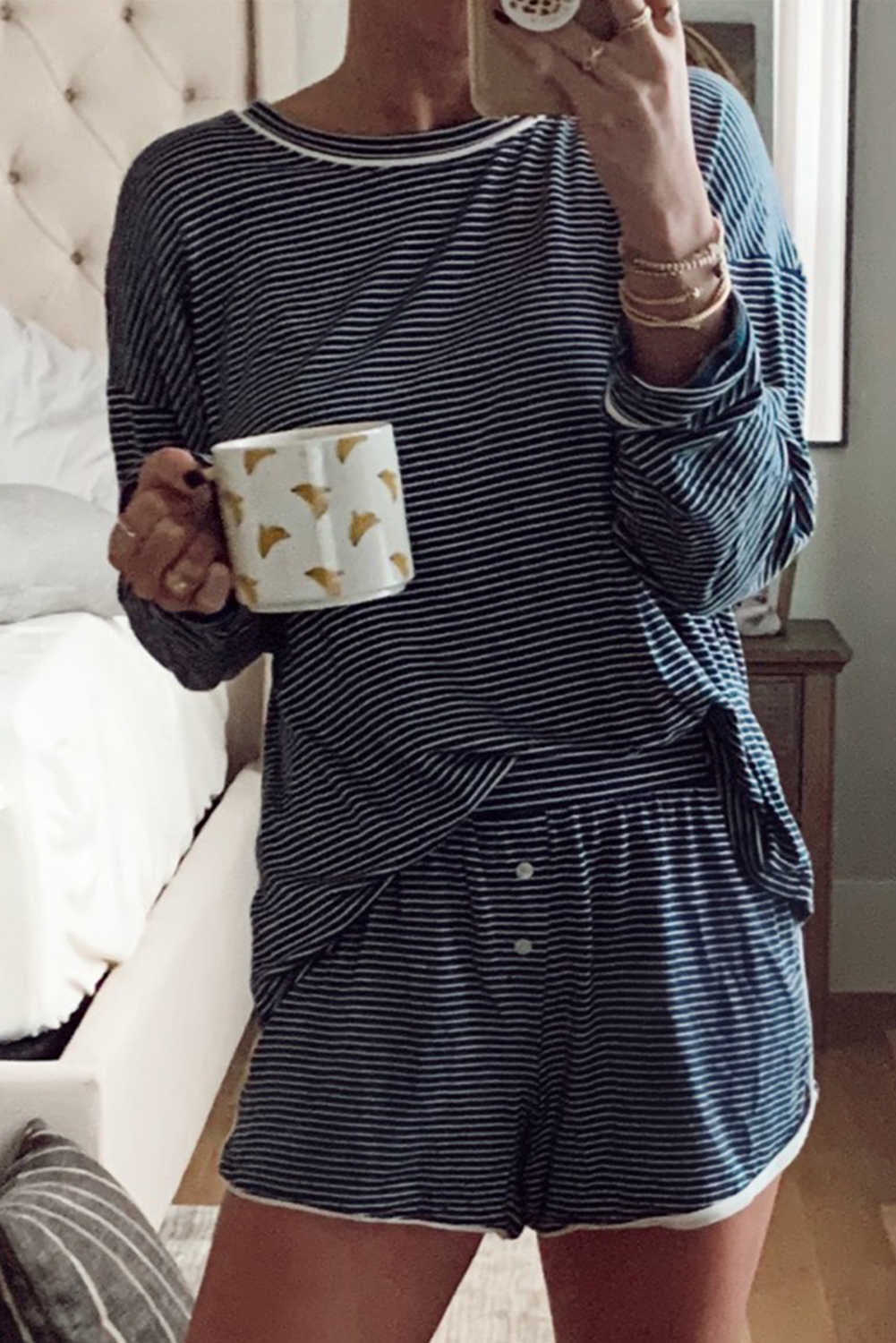 Conjunt de dues peces de samarreta de màniga llarga amb coll rodó i espatlles caigudes a ratlles blaves i pantalons curts amb botons