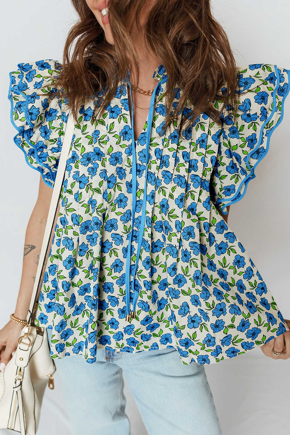 Brusa plisada de flors amb mànigues ondulades a capes blau cel