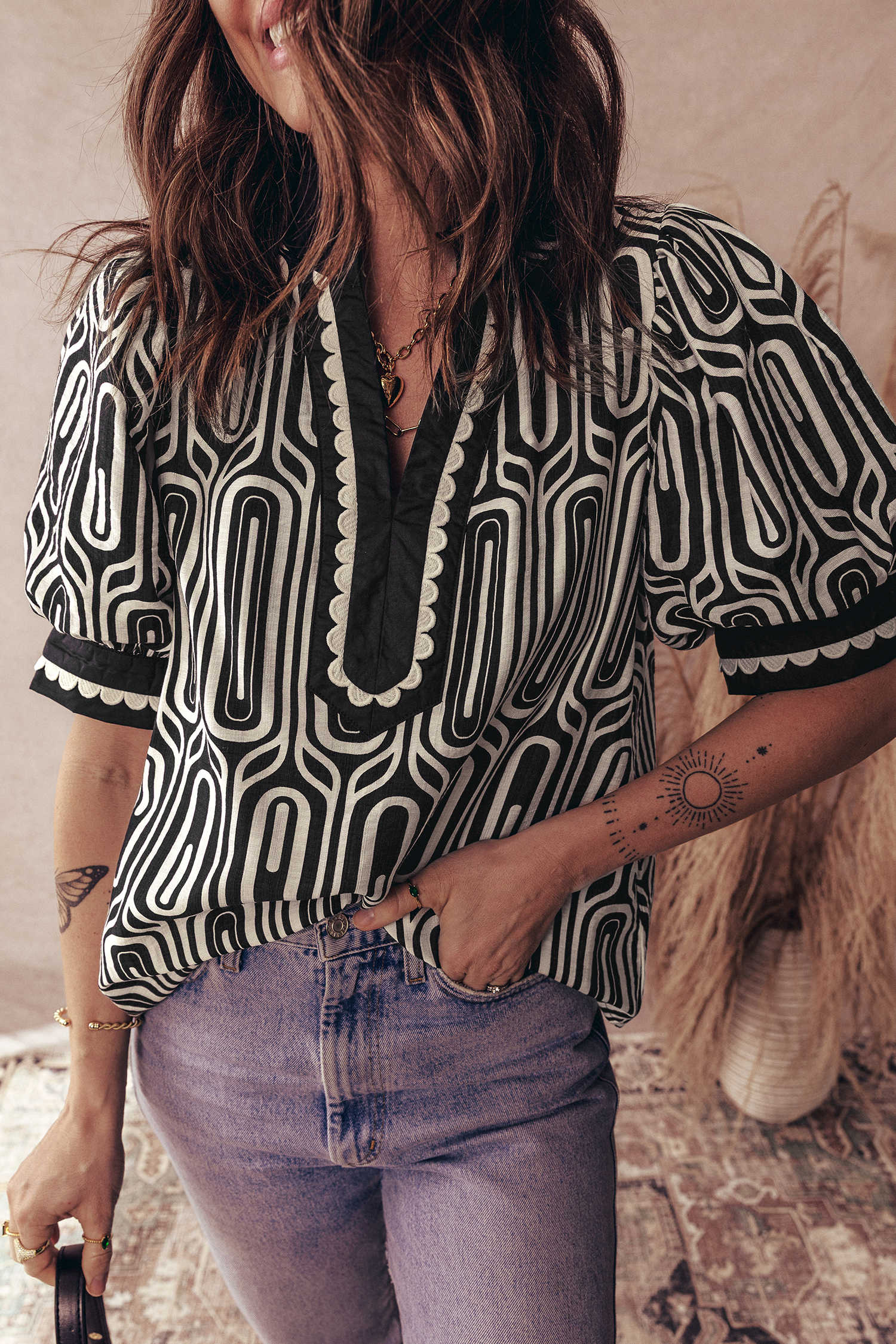 Brusa negra de màniga curta amb estampat geomètric en contrast amb pegats de blocs de color amb pegats