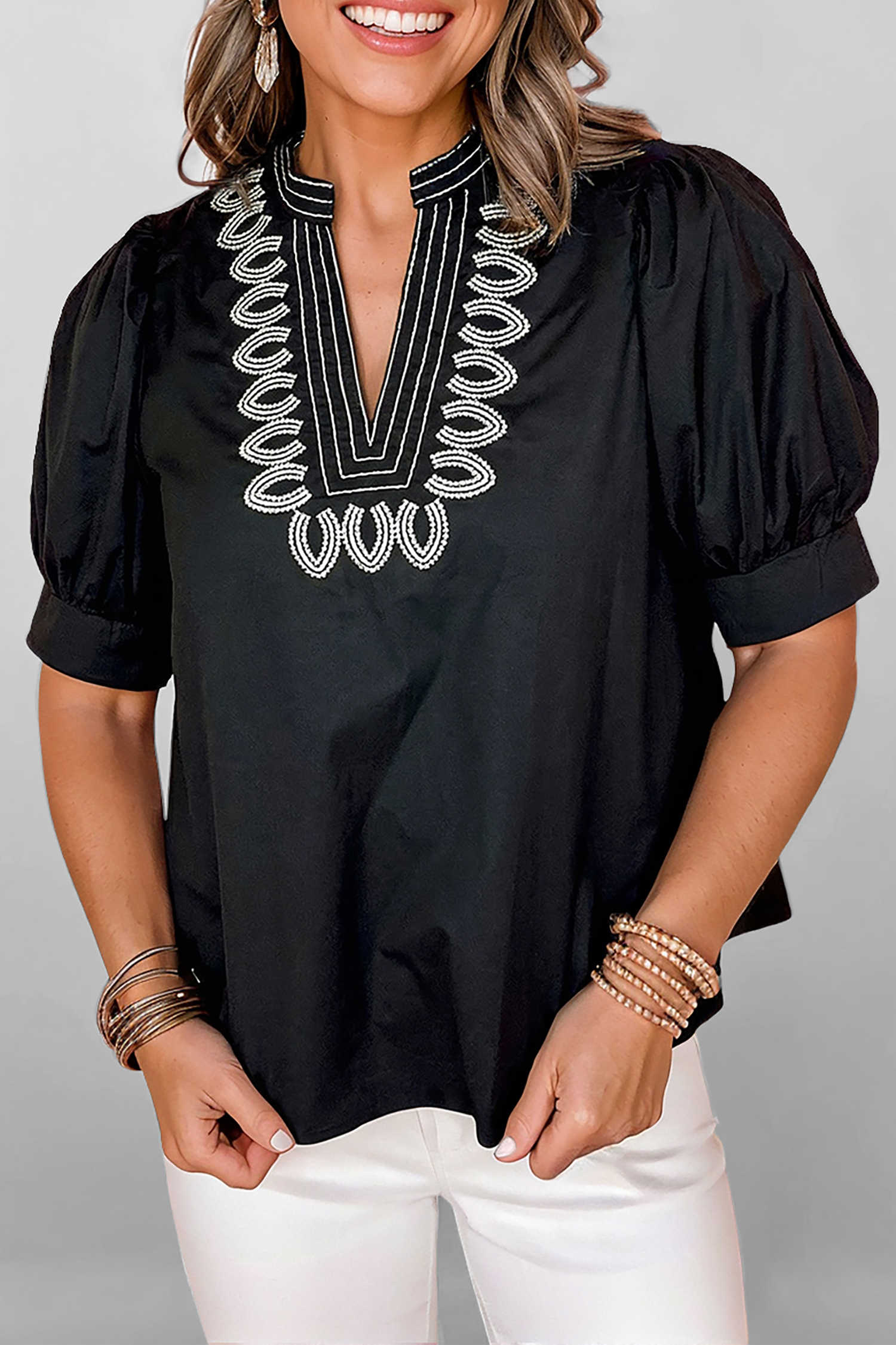 Brusa negra de màniga curta amb coll en V i detall brodat en contrast