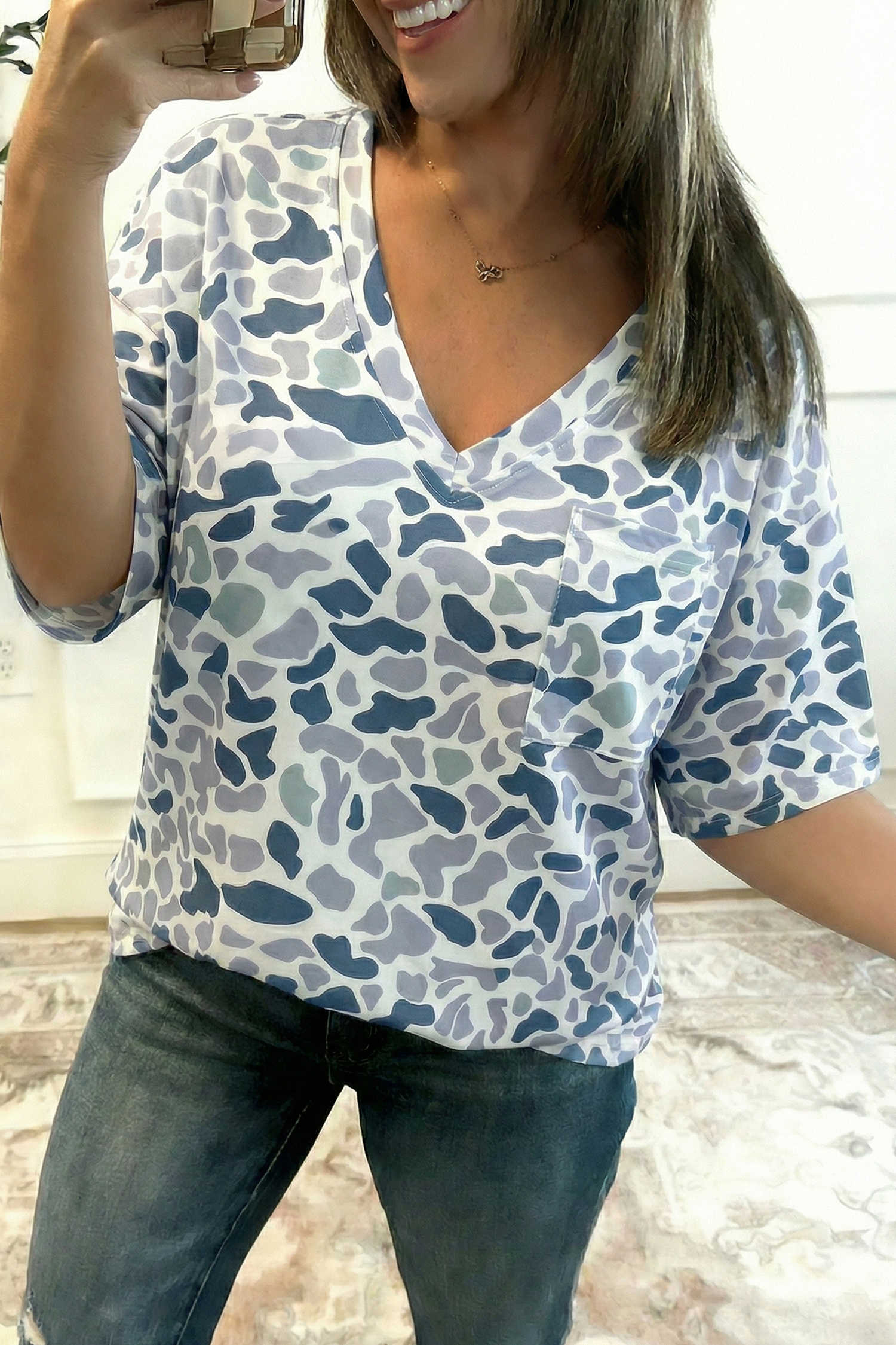 Samarreta grisa amb coll en V i estampat de camuflatge amb una sola butxaca al pit